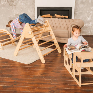 Children are playing inside.  Children's furniture  Pikler Arch Pikler ramp and Pikler Triangle  Color: Naturally wood  Transformer Kitchen tower and training table with stand for the back.